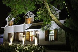 una casa blanca con luces delante en 3 Liebeloft Guest House, en Edenvale