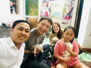 a family sitting on the floor holding stuffed animals at Nam Mỹ Vân Homestay - ĐH Công nghiệp Thái Nguyên in Thái Nguyên