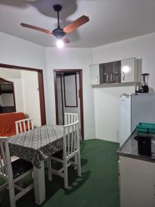 a kitchen with a table and chairs and a ceiling fan at pousada top mix apt 202 in Florianópolis