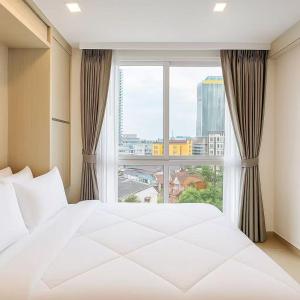 Ένα ή περισσότερα κρεβάτια σε δωμάτιο στο 芭提雅市中心Olympus 水系公寓酒店 健身房 步行街 海滩附近 一居室 +50 φωτογραφίες