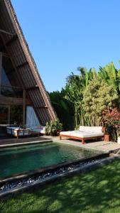 a swimming pool in a yard with a house at The Sawah Lodge, Seseh-Bali in Seseh