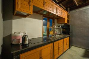 a kitchen with wooden cabinets and a counter top at Vân Hòa Phú Yên homestay highland in Tuy Hoa