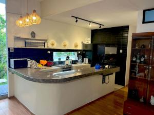 eine große Küche mit einer Arbeitsplatte in einem Zimmer in der Unterkunft Casa Greemat 3Habs con AC, piscina y a pasos del mar in Zorritos