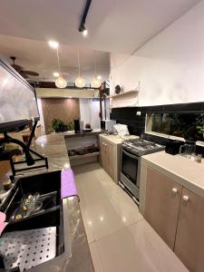 eine große Küche mit Geräten und Arbeitsplatten aus Edelstahl in der Unterkunft Casa Greemat 3Habs con AC, piscina y a pasos del mar in Zorritos