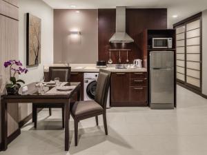 a kitchen with a table and a kitchen with a refrigerator at Grand Mercure Bangkok Asoke Residence in Bangkok +125 photos