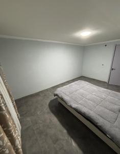 Un dormitorio con una cama en la esquina de una habitación. en wwaallee, en Kutaisi