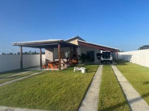 ein Haus mit einer großen Wiese davor in der Unterkunft CONDOMINIO MERIDIEN PRAIA MAR Praia do Abais in Estância