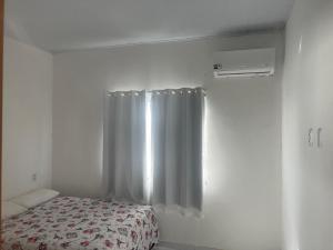 ein Schlafzimmer mit einem Bett und einem Duschvorhang in der Unterkunft CONDOMINIO MERIDIEN PRAIA MAR Praia do Abais in Estância + 14 Fotos