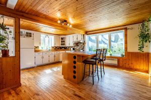 a kitchen with a wooden ceiling and a table and chairs at Le 1871 séjour champêtre et lumineux et Mauricie in Shawinigan