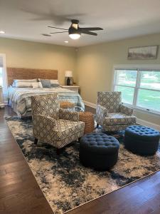 ein Schlafzimmer mit einem Bett, zwei Stühlen und einem Bett in der Unterkunft Arcadia Shores On The Cove in Easton