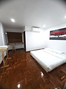 a bedroom with a bed and a table in it at A Day Home in Chiang Mai