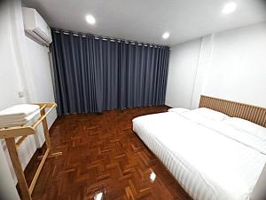 a bedroom with a bed and a blue curtain at A Day Home in Chiang Mai +4 photos