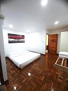 a bedroom with a bed and a painting on the wall at A Day Home in Chiang Mai