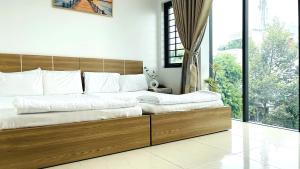 ein großes Bett mit einem Holzrahmen in einem Schlafzimmer in der Unterkunft Ruby Star Hotel Apartment in Vũng Tàu