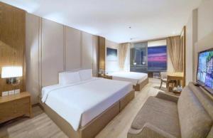 a bedroom with two beds and a flat screen tv at Panorama Win Residences Nha Trang in Nha Trang