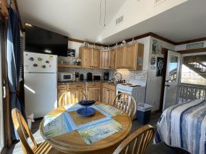 ハッテラスにある39 ALMOST HEAVEN condoのテーブルと椅子と冷蔵庫のあるキッチン +4枚の写真