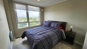 een slaapkamer met een bed en een groot raam bij Espectacular departamento 2D2B, súper ubicación, con estacionamiento in Los Ángeles