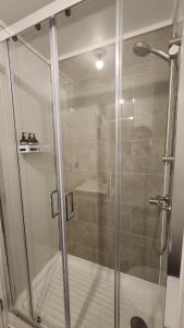 een douche met een glazen deur in een badkamer bij Espectacular departamento 2D2B, súper ubicación, con estacionamiento in Los Ángeles