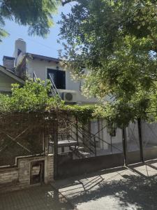 a fence in front of a house with a building at casa particular adrogue entrada individual in José Mármol