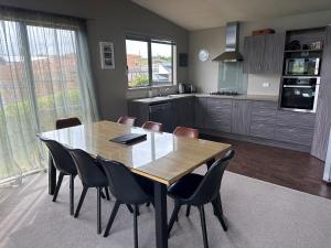 a kitchen with a dining room table and chairs at Sunny Bob Lee Place in Wanaka