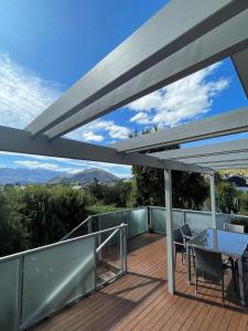 a patio with a table and chairs on a deck at Sunny Bob Lee Place in Wanaka