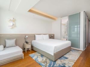 a bedroom with two beds and a window at Pullman Bangkok King Power in Bangkok