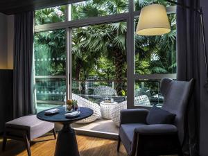 a living room with a table and a large window at Pullman Bangkok King Power in Bangkok