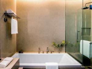 a bathroom with a white tub and a shower at Pullman Bangkok King Power in Bangkok +155 photos