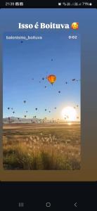 a picture of a field with kites flying in the sky at Meu Refúgio in Boituva