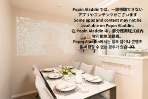 a dining room with a table with chairs and a wall at The Guest Villa 箱根湯本 V-I in Hakone