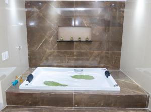 a bathroom with a bath tub in a bathroom at Pousada Villa Goyá in São José da Coroa Grande