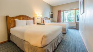 een hotelkamer met twee bedden en een raam bij Cahilty Lodge in Sun Peaks