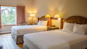 een hotelkamer met twee bedden en een raam bij Cahilty Lodge in Sun Peaks