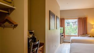 een hotelkamer met een bed en een raam bij Cahilty Lodge in Sun Peaks +235 foto's