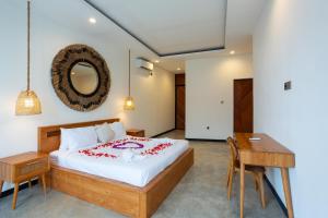 a bedroom with a bed and a desk and a mirror at Chopik Villa in Dalung