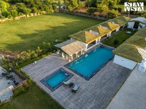 an aerial view of a backyard with a swimming pool at StayVista at Rissaca Crown with Bonfire in Jaipur