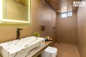 a bathroom with a sink and a toilet at StayVista at Rissaca Crown with Bonfire in Jaipur