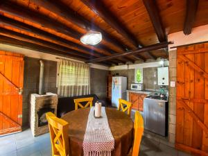 a kitchen and dining room with a table and chairs at Cabañas El Nogal in Villa Anizacate
