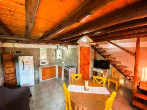 a kitchen with a table and a refrigerator at Cabañas El Nogal in Villa Anizacate