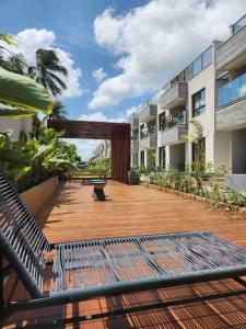 a patio of a apartment building with a bench at Apartamento à beira-mar em São Miguel do Gostoso in São Miguel do Gostoso