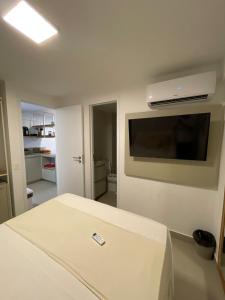 a room with a bed and a flat screen tv at Apartamento à beira-mar em São Miguel do Gostoso in São Miguel do Gostoso +11 photos