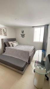 ein Schlafzimmer mit einem Bett und einem Glastisch in der Unterkunft Apartamento en San Gil, in San Gil + 19 Fotos