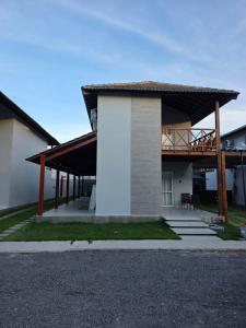 a house with a balcony and a deck at Praia dos Carneiros Condomínio Village in Tamandaré