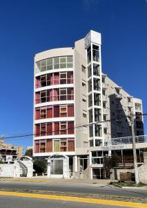 a tall white building on the side of a street at Apart Hotel Bs.As.Mar in San Clemente del Tuyú
