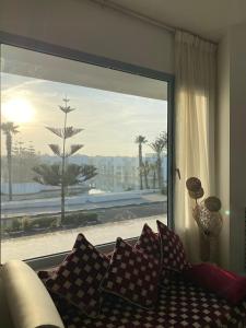 uma sala de estar com um sofá e uma janela grande em Pearl Of Eden Island em Bouznika