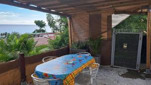 Un patio con una mesa y sillas en un balcón. en Evasion Nord Caraïbe vue mer -plage 5 mn à pieds, en Le Carbet 6 fotos más