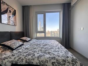 ein Schlafzimmer mit einem Bett und einem großen Fenster in der Unterkunft Beijing City center - One bedroom flat with two beds and CBD view in Peking