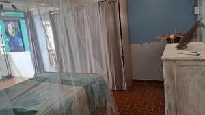 Habitación con mesa y cortina blanca en Evasion Nord Caraïbe vue mer -plage 5 mn à pieds, en Le Carbet