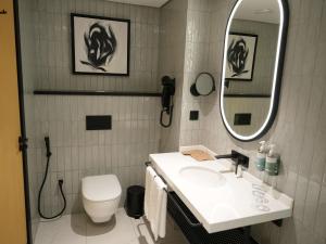 a bathroom with a sink and a toilet and a mirror at Novotel Riyadh Al Anoud in Riyadh
