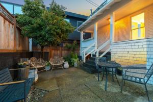 eine Terrasse mit Stühlen und Tischen sowie ein Haus in der Unterkunft Home & Carriage House Views Dogs Welcome BBQ in Edmonds
